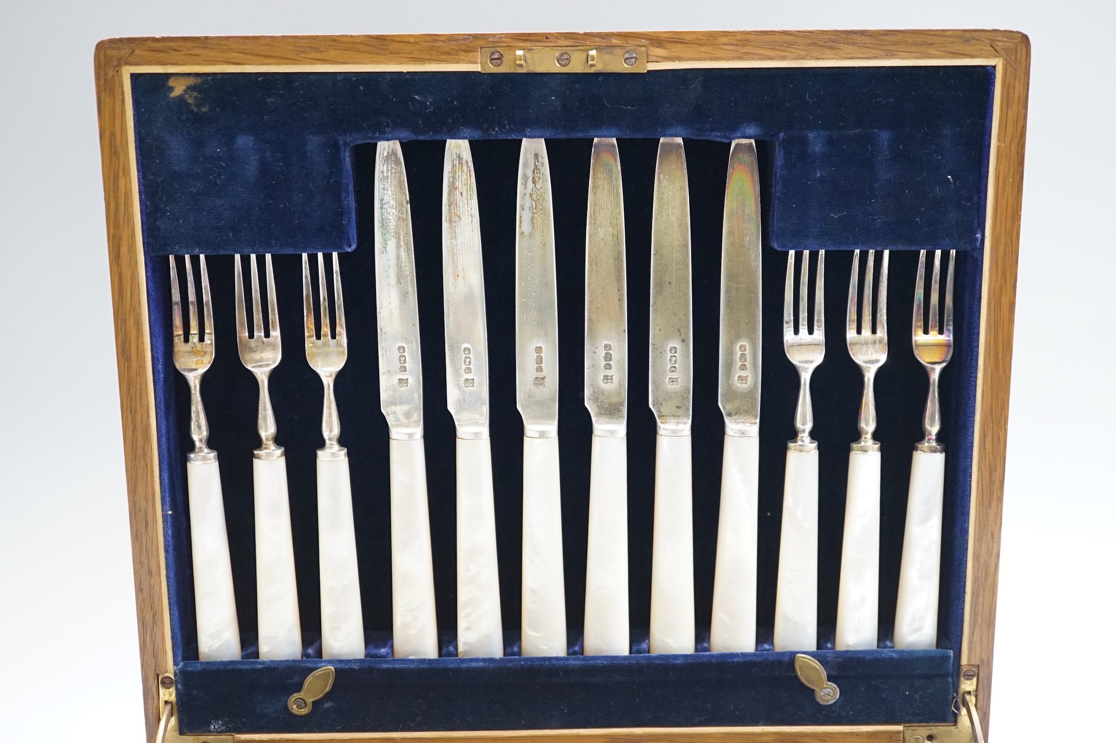 A cased set of twelve pairs of George V mother of pearl handled silver dessert eaters, Isaac Ellis & Sons, Sheffield, 1924.